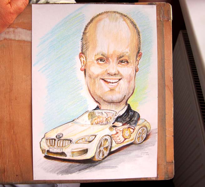 Мужчина с улыбкой едет на машине шаржист Михаил Шабалин, шаржист Мишель 